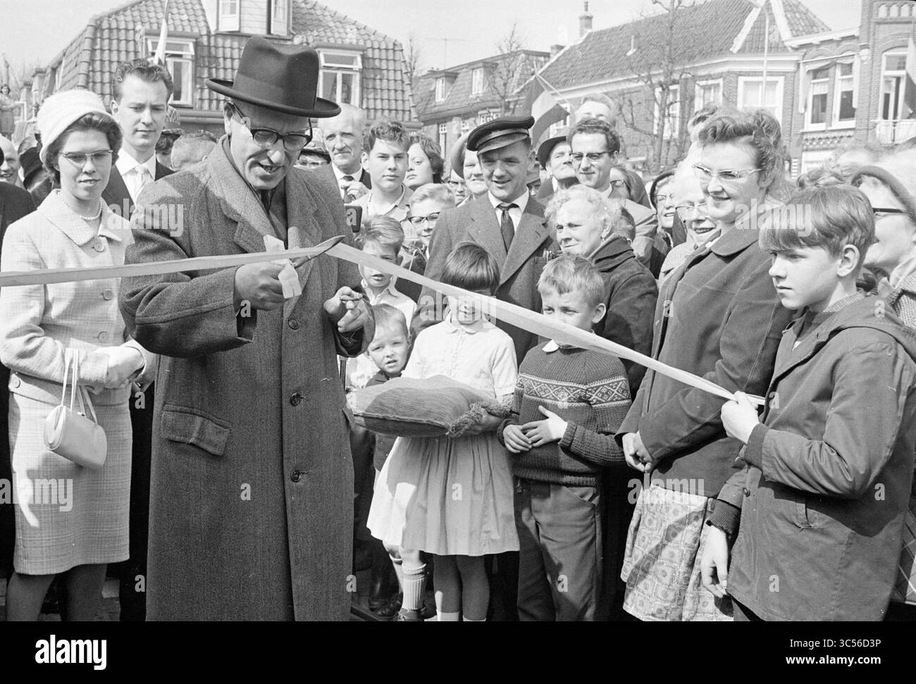 Ouverture du nouveau marché lisse, marché, ouverture, ouvertures, mise en service, 08-04-1963 Whizgle News, Dutch Desk, pays-Bas, 1950-2000 Une foule nombreuse se rassemble avec impatience alors qu'un homme portant un chapeau se prépare à couper un ruban, marquant l'ouverture d'un nouvel événement ou d'un nouveau lieu. Les enfants et les adultes regardent avec anticipation, mettant en valeur un moment de célébration et d'esprit communautaire. Banque D'Images