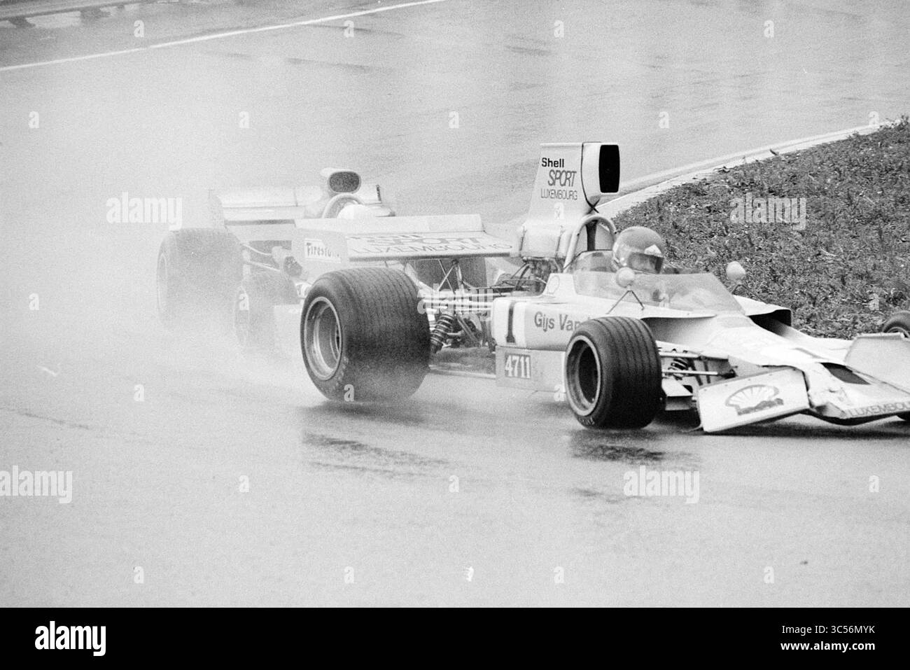 Course automobile sur le circuit de Zandvoort avec Gijs van Lennep, Zandvoort Whizgle News, Dutch Desk, pays-Bas, 1950-2000 deux voitures de course naviguent sur une piste mouillée, leurs pneus éclaboussant à travers des flaques d'eau alors qu'elles s'affrontent pour se positionner au milieu d'un rideau de brouillard et de brouillard. La scène capture l'intensité et l'excitation du sport automobile dans des conditions difficiles. Banque D'Images