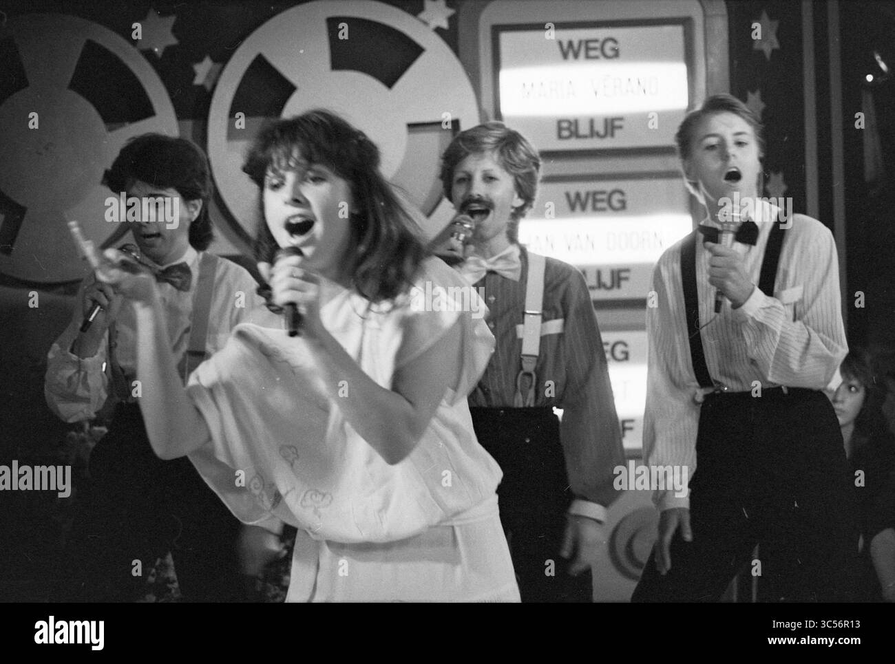 Playback Competition disco Zandvoort, Competition, Zandvoort, 09-10-1983 Whizgle News, Dutch Desk, les pays-Bas, 1950-2000 Une performance dynamique mettant en vedette quatre chanteurs, dont un dirigeant passionnément le groupe tout en tenant un micro, entouré d'une scène vibrante. Les interprètes présentent un mélange de poses enthousiastes, portant des tenues élégantes qui reflètent une atmosphère ludique et énergique. Banque D'Images