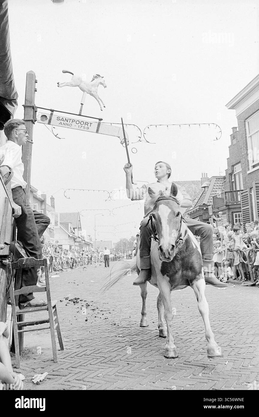 Couture d'anneau sur cheval à Santpoort, Santpoort, 05-08-1969 Whizgle News, Dutch Desk, pays-Bas, 1950-2000 Un cavalier à cheval navigue habilement dans un événement festif, visant à frapper un objet suspendu au-dessus de lui, tandis que les spectateurs regardent avec impatience depuis les lignes de touche. L'atmosphère est animée, remplie d'anticipation et d'excitation au fur et à mesure que la compétition se déroule. Banque D'Images