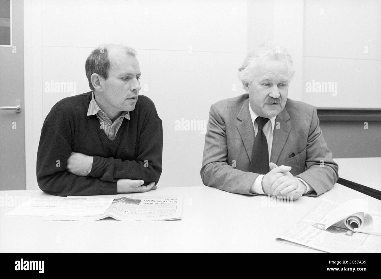 Heren van Kam et Streuker enseignent les hauts fourneaux, les hauts fourneaux, l'éducation personnelle, IJmuiden, pays-Bas, 08-10-1984 Whizgle News, Dutch Desk, pays-Bas, 1950-2000 deux hommes sont assis à une table, engagés dans une conversation. Un homme a les bras croisés et semble réfléchi, tandis que l'autre est penché légèrement en avant, les mains serrées. Les deux sont habillés en tenue formelle ou semi-formelle, avec des journaux disposés devant eux. Le cadre transmet un sens de discussion ou de délibération. Banque D'Images