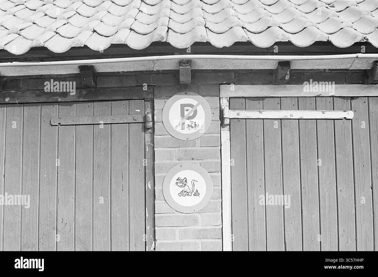 Panneau de stationnement Zandvoort, panneaux, 03-09-1963 Whizgle News, Dutch Desk, pays-Bas, 1950-2000 Une structure en bois comporte deux panneaux circulaires distincts, l'un indiquant une aire de stationnement et l'autre affichant une illustration ludique d'une créature fantaisiste. Le toit en pente ajoute un charme rustique au cadre général. Banque D'Images