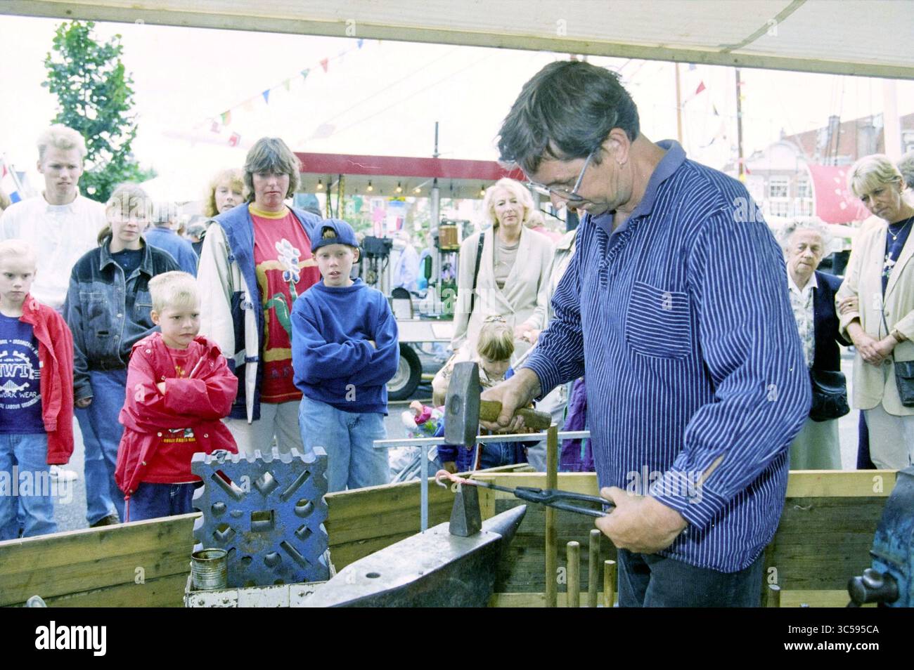 Div., Sailing Days, Spaarne, 01-09-1995 Whizgle News, Dutch Desk, pays-Bas, 1950-2000 Un forgeron habile démontre l'art du travail des métaux devant un public engagé, y compris des enfants et des adultes fascinés. L'atmosphère vibrante capture la curiosité et l'excitation des spectateurs qui regardent l'engin prendre vie. Banque D'Images