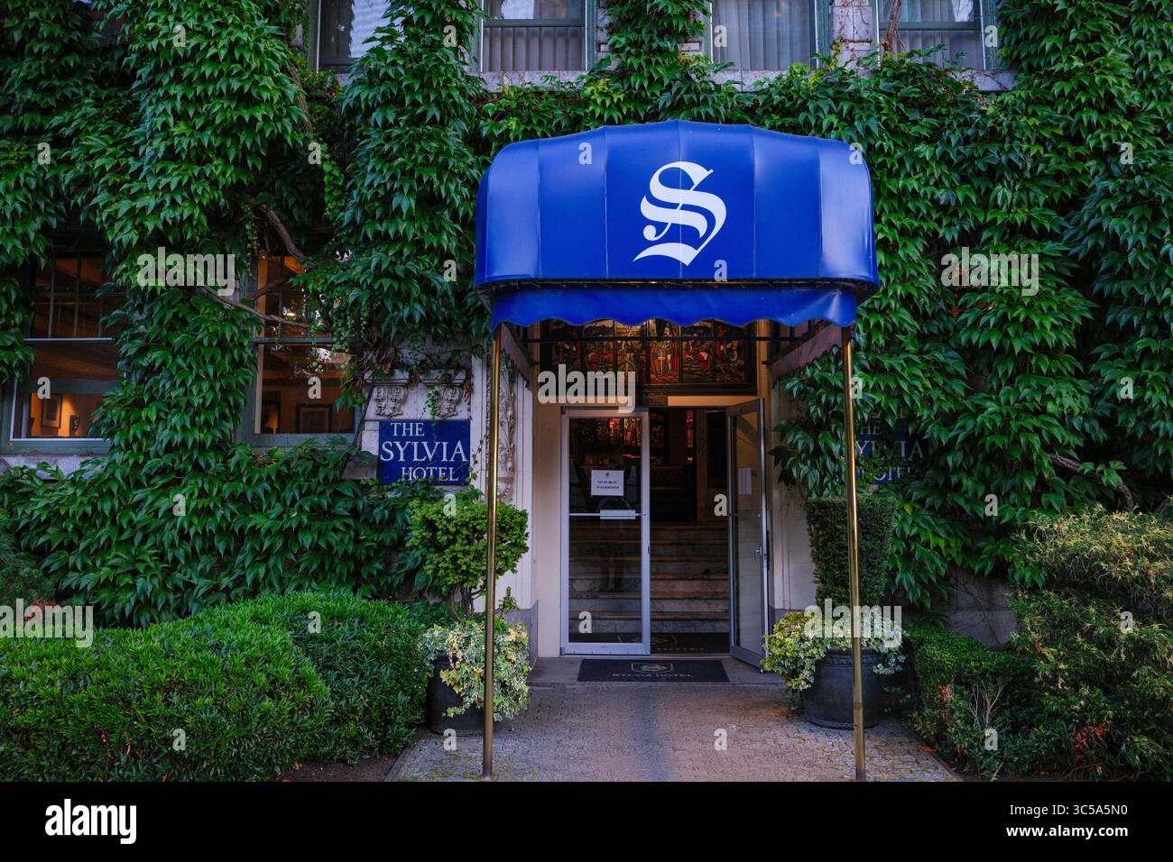 L'auvent et l'entrée de l'hôtel historique Sylvia entouré de vignes creeper de Virginie par English Bay à Vancouver, en Colombie-Britannique. Banque D'Images
