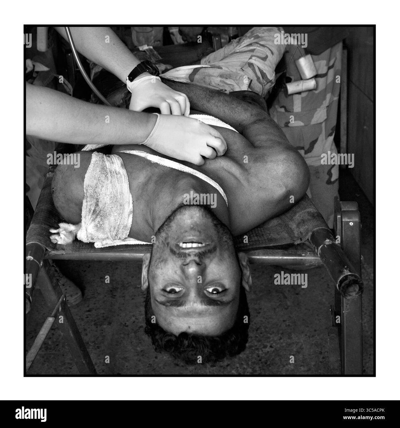 15 juillet 2017 - Mossoul, Irak - une infirmière de Global Response Management traite un soldat grièvement blessé. Des soldats de l'armée irakienne blessés reçoivent des soins médicaux d'urgence à un point de stabilisation des traumatismes le 15 juillet 2017 au milieu des ruines de la vieille ville. Le bilan de la guerre - même avec des efforts médicaux héroïques, ce soldat est mort dans l'ambulance sur le chemin de l'hôpital. La bataille avec l'Etat islamique se poursuit dans une petite partie de Mossoul occidental sur le Tigre, même si elle a été déclarée libérée il y a quelques jours. Les blessures causées par les kamikazes, les grenades et les tireurs d'élite continuent alors que les combattants de l'Etat islamique utilisent les tunnels pour poursuivre la féroce Banque D'Images