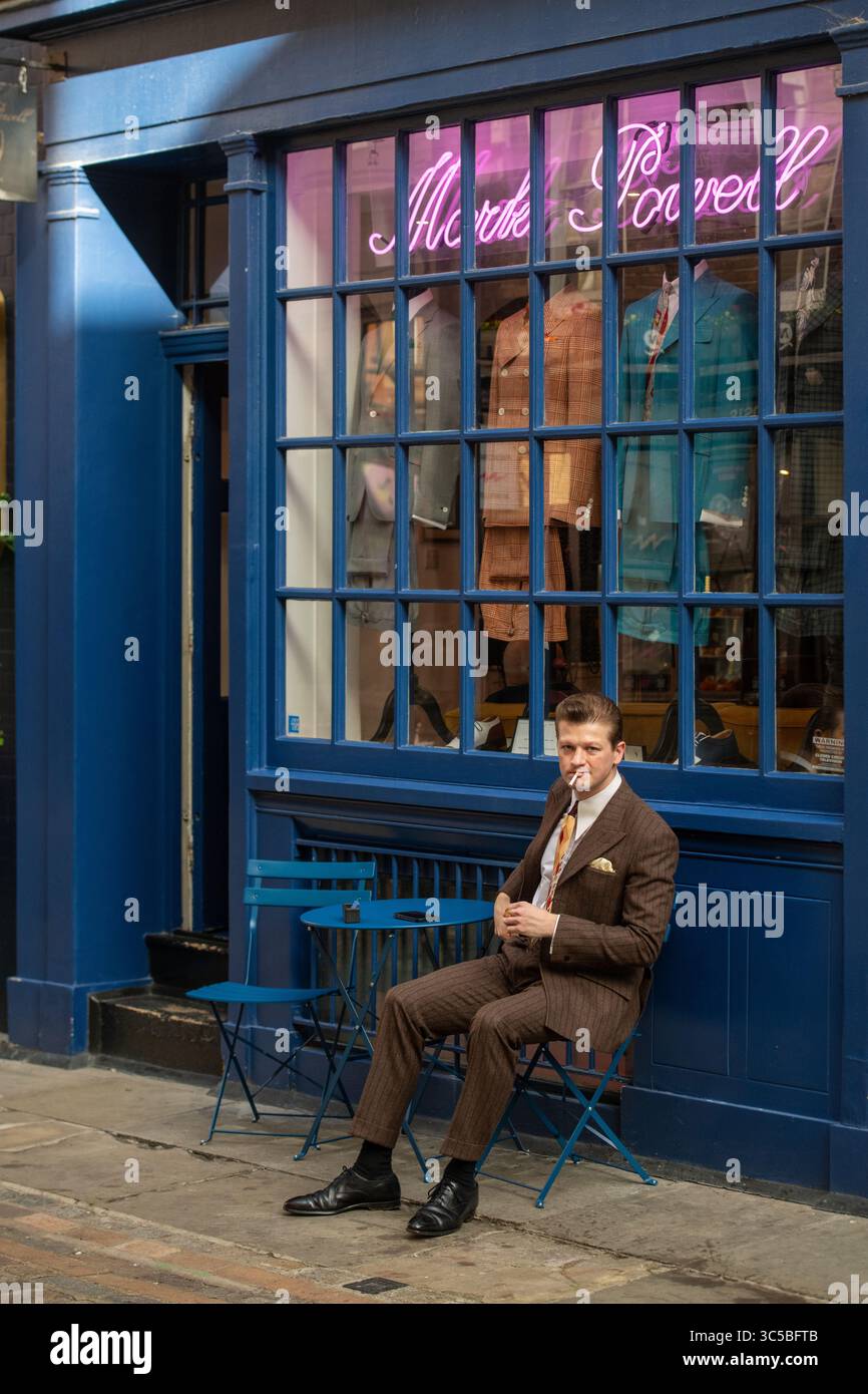 Homme bien habillé pose devant l'emblématique magasin Mark Powell de Soho, Londres, mettant en vedette des vêtements masculins britanniques classiques et le style Carnaby Street. Banque D'Images