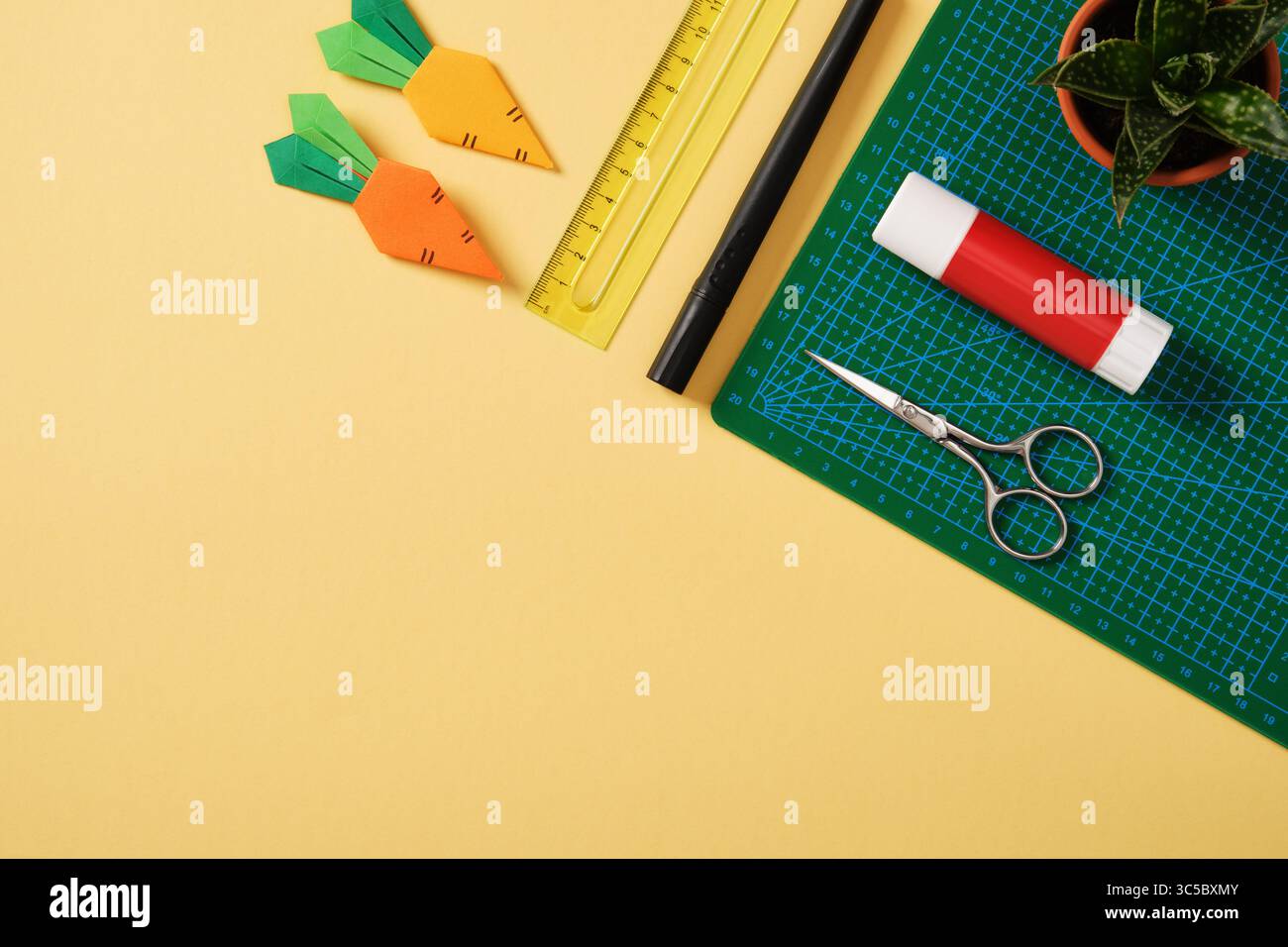 Fournitures pour le passe-temps de l'art du papier : ciseaux, couteau artisanal, crayon, gomme, papier coloré. Espace pour votre texte. Papier artisanat table de travail plat. Banque D'Images