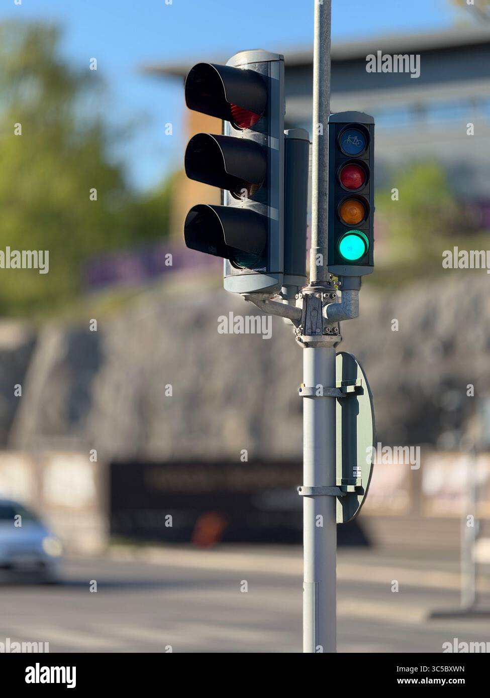Feu de circulation avec feu vert et lumière de vélo en mise au point, photographié par temps clair. Infrastructure urbaine et concept de sécurité routière en Suède. - Image de stock capturée avec un smartphone