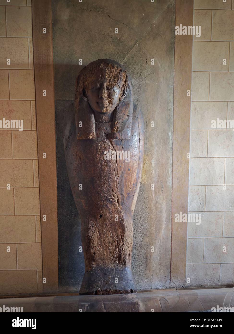 Ancien sarcophage égyptien encastré dans un mur, partiellement endommagé mais montrant clairement une figure humaine sculptée avec une coiffe. Prise au château de Buchlov Banque D'Images