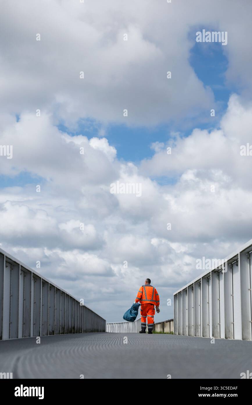Hambourg, Allemagne. 30 juillet 2025. Un employé du service de nettoyage de la ville de Hambourg marche le long du chemin d'horizon sur l'IBA Energy Hill Georgswerder et vide les poubelles. Crédit : Christian Charisius/dpa/Alamy Live News Banque D'Images