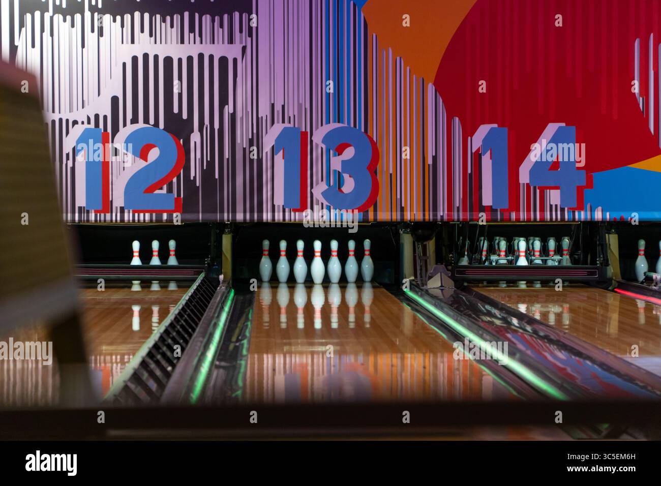 Pistes de bowling vides avec des épingles sur un jeu de bowling de nuit Banque D'Images