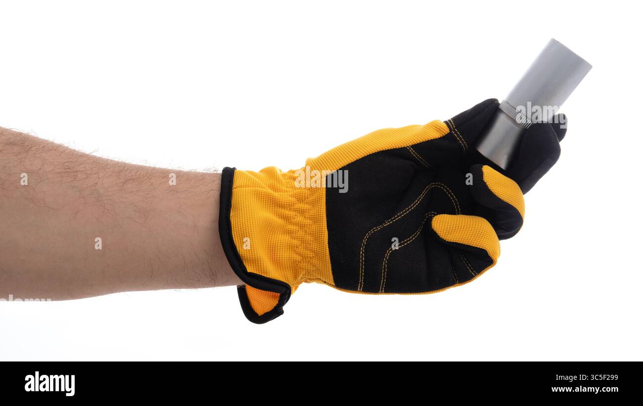 Main gantée tenant un outil métallique pour le travail Banque D'Images