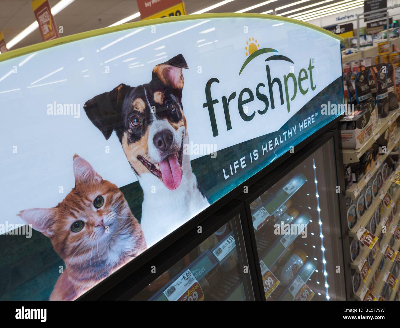 Logo Freshpet affiché sur le réfrigérateur à portes vitrées pour animaux avec repas sains pour chiens visibles - Image de stock capturée avec un smartphone