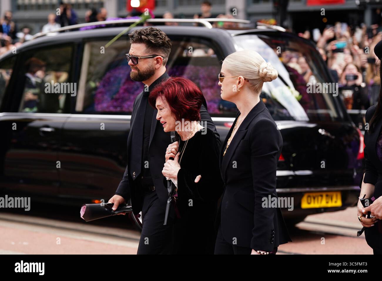 La famille d'Ozzy Osbourne (de gauche à droite) Jack Osbourne, Sharon Osbourne et Kelly Osbourne déposent des fleurs et regardent les messages et hommages floraux laissés sur le banc du pont Black Sabbath sur Broad Street à Birmingham en mémoire du chanteur Black Sabbath Ozzy Osbourne, alors que son corps est ramené dans sa ville natale pour une procession après sa mort la semaine dernière à l'âge de 76 ans. Date de la photo : mercredi 30 juillet 2025. Banque D'Images