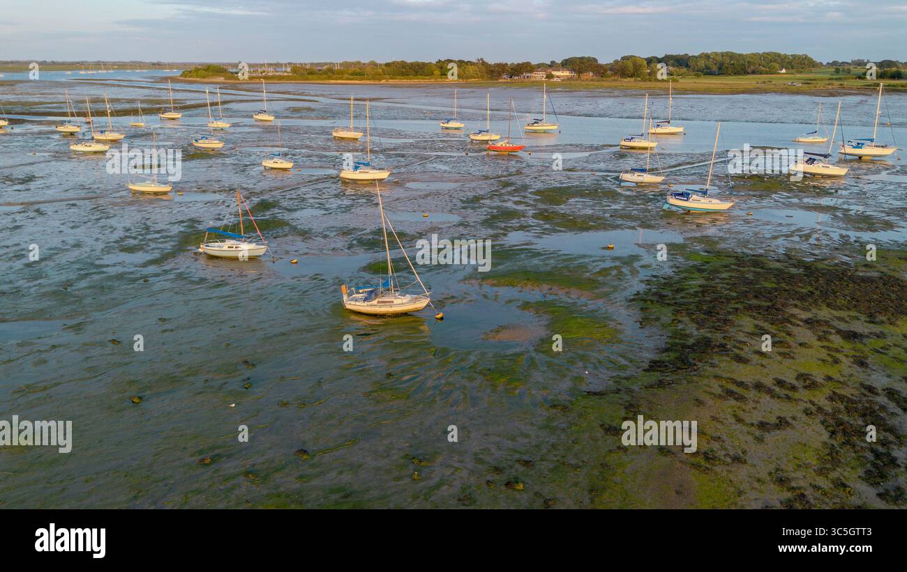 Vue aérienne de voiliers amarrés à marée basse à Sweare Deep entre Hayling Island et Havant, Hampshire, Royaume-Uni. Banque D'Images