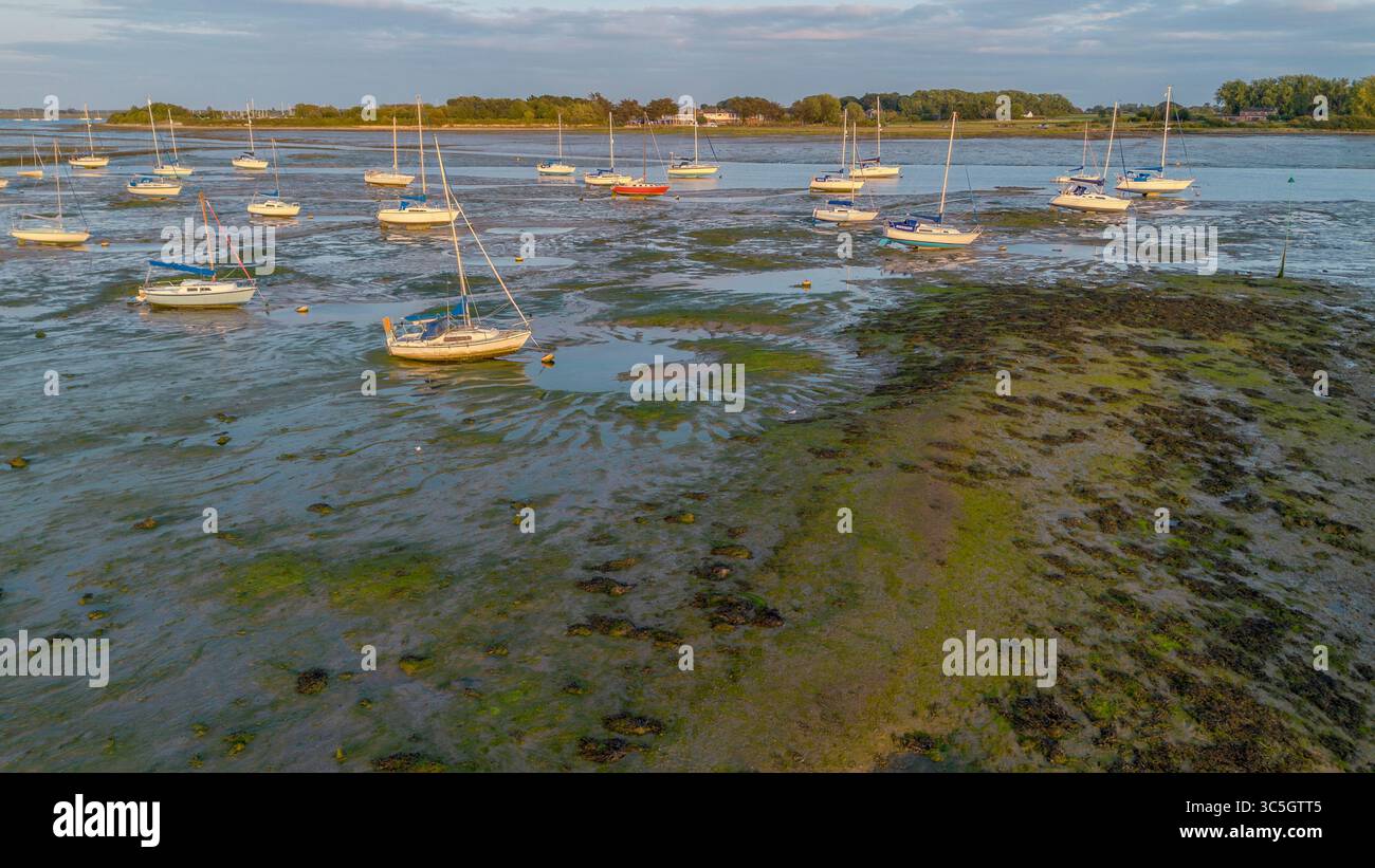 Vue aérienne de voiliers amarrés à marée basse à Sweare Deep entre Hayling Island et Havant, Hampshire, Royaume-Uni. Banque D'Images