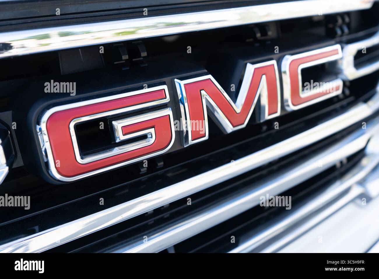 Logo GMC sur la calandre élégante des voitures sous l'éclairage naturel de la salle d'exposition Banque D'Images