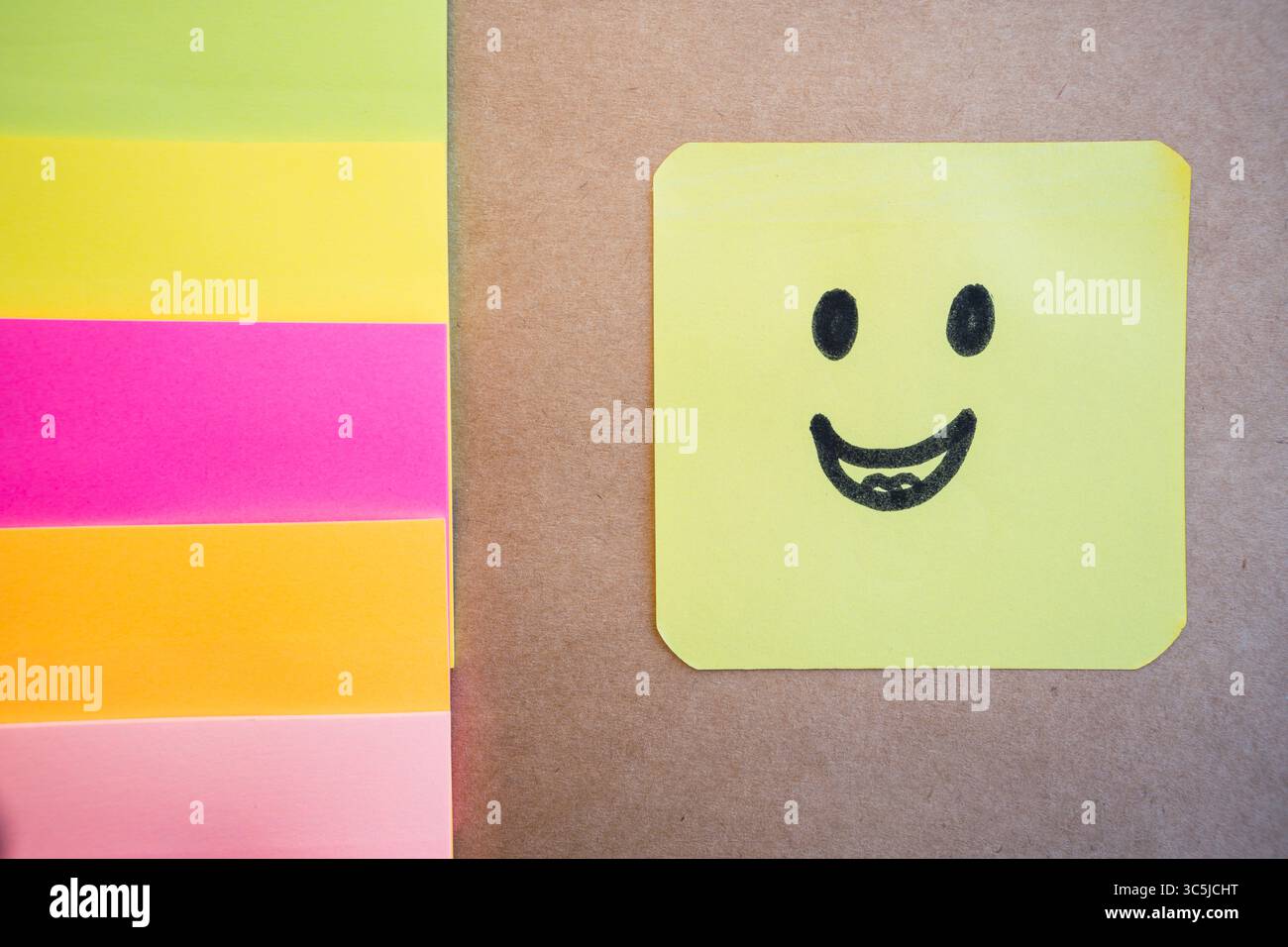 Visage heureux dessiné sur du papier coloré avec un marqueur noir avec un fond Uni uniforme Banque D'Images