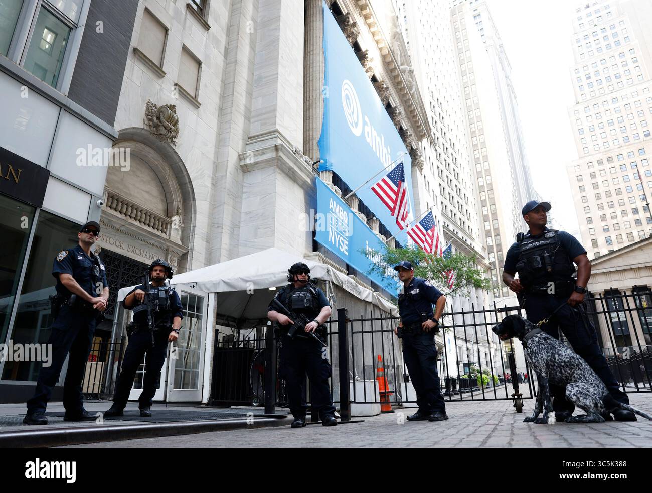New York, États-Unis. 30 juillet 2025. Les policiers du NYPD se tiennent debout avec un chien détecteur d'explosifs détenu par un agent de lutte contre le terrorisme du NYPD à l'entrée de la Bourse de New York sur Wall Street le mercredi 30 juillet 2025 à New York. Les actions AMÉRICAINES se sont maintenues stables mercredi en attendant une décision de taux d'intérêt de la réserve fédérale cet après-midi. Photo de John Angelillo/UPI crédit : UPI/Alamy Live News Banque D'Images