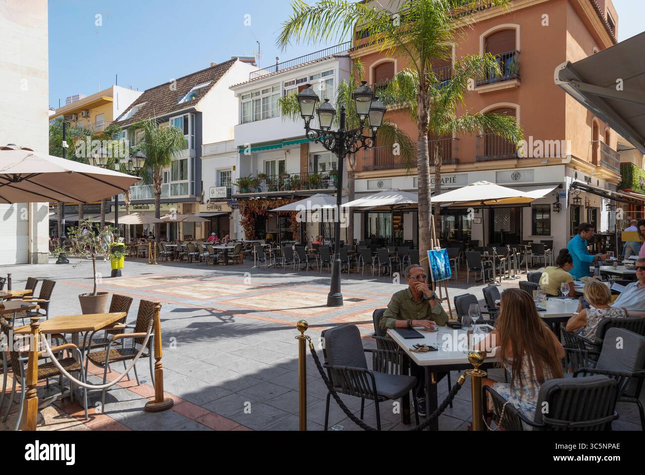 Les gens sur la terrasse sur une petite place dans le centre de la station balnéaire de Fuengirola en Espagne. Banque D'Images