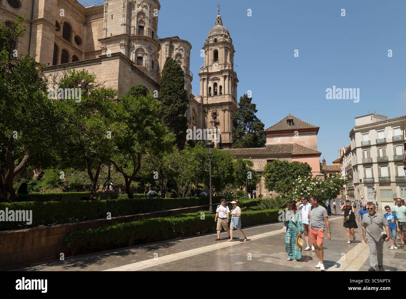 Les touristes passent devant la cathédrale ou Santa Iglesia Catedral Basílica de la Encarnación à Malaga en Espagne. Banque D'Images