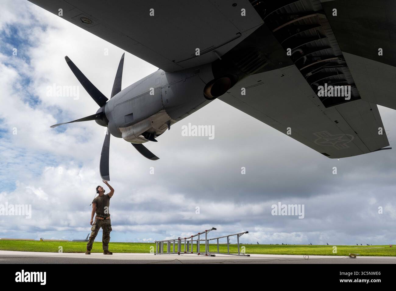 14 juillet 2025 - Guam - L'aviateur principal de l'US Air Force Luke Baugh, un chef d'équipage affecté au 19e escadron de maintenance d'aéronefs de la base aérienne de Little Rock, effectue une inspection après vol d'un C-130J Super Hercules lors de la série d'exercices de niveau département de l'Air Force 2025 à la base aérienne d'Andersen, Guam, le 14 juillet 2025. Cet exercice montre comment la Force aérienne existe pour manœuvrer la Force interarmées dans n'importe quel théâtre d'opération pour répondre aux exigences mondiales. Le lancement de l'avion fait partie de la première série DLE de génération, une nouvelle façon de mener des opérations dans un environnement dynamique et contesté Banque D'Images