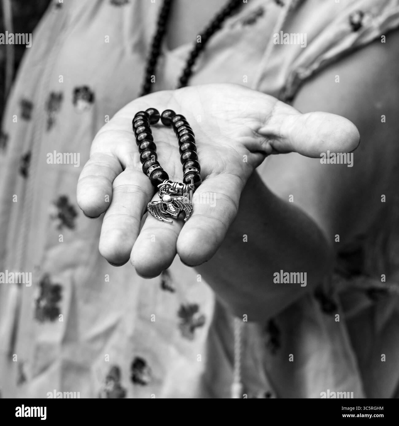 Main tenant un bracelet mala spirituel en noir et blanc. Banque D'Images