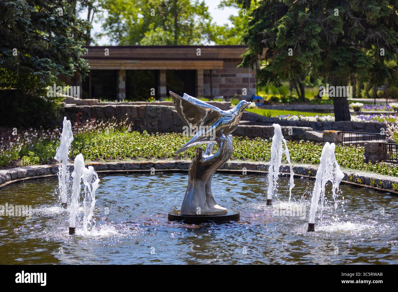 Dunseith, ND, États-Unis - 05 juillet 2025 : une fontaine sereine au jardin international de la paix représente une colombe volant gracieusement de mains Banque D'Images