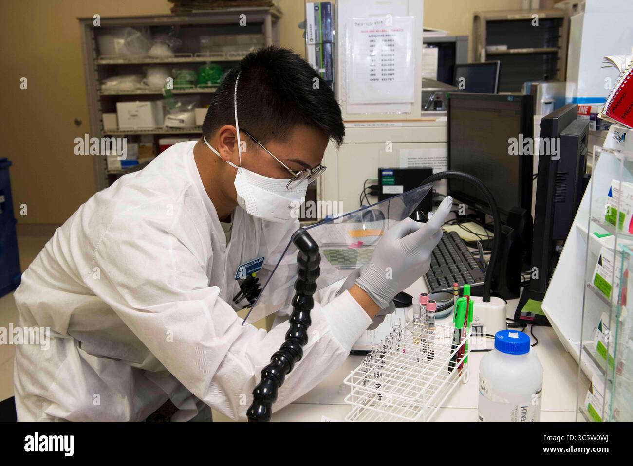 25 mars 2020 - Travis AFB, Californie, États-Unis - Air Force Airman 1st Class Michael San Jose, technicien de laboratoire du 60th Medical Diagnostics and Therapeutics Squadron, effectue le titrage des anticorps à l'intérieur du laboratoire David Grant USAF Medical Center le 25 mars 2020, à la base aérienne de Travis, Californie. Le laboratoire, qui soutient le commandement de la mobilité aérienne, ainsi que le théâtre Pacifique, est l’un des nombreux services que le centre médical fournit pendant la pandémie de COVID-19. (Crédit image : © James Hodgman/U.S. Air Force/ZUMA Wire/ZUMAPRESS.com) Banque D'Images