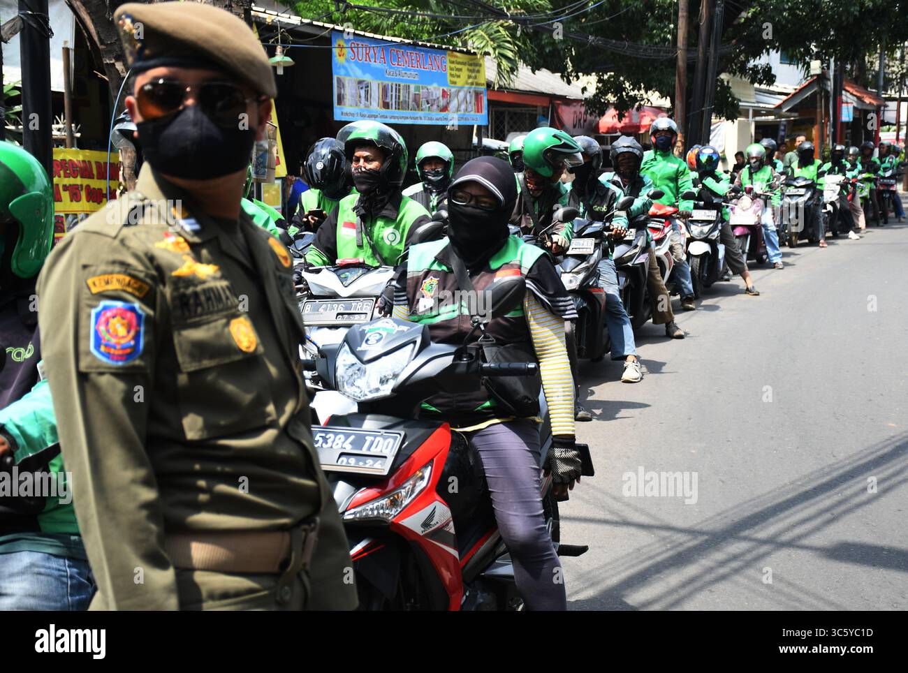 5 septembre 2019, Cipayung, Jakarta, Indonésie : les chauffeurs de moto-taxi en ligne sont prêts à faire la queue pour obtenir des provisions de bénévoles dans la région de Cipayung, Jakarta, le 18 avril 2020. Pas moins de 200 colis alimentaires ont été distribués en ligne aux chauffeurs de motos-taxis, car depuis que la co-pandémie a eu lieu en Indonésie, leurs revenus ont diminué. Depuis les nombreuses commandes précédentes pour le transport, les utilisateurs utilisent maintenant des chauffeurs pour commander de la nourriture, magasiner pour les nécessités quotidiennes ou livrer des marchandises. (Crédit image : © Dasril Roszandi/ZUMA Wire) Banque D'Images