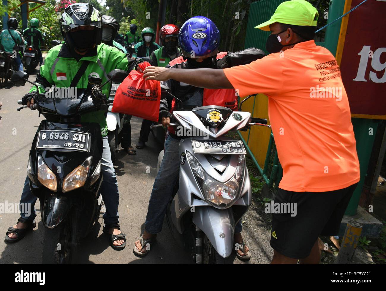 5 septembre 2019, Cipayung, Jakarta, Indonésie : des volontaires donnent des colis alimentaires aux chauffeurs de moto-taxi en ligne dans la région de Cipayung, Jakarta, le 18 avril 2020. Pas moins de 200 colis alimentaires ont été distribués en ligne aux chauffeurs de motos-taxis, car depuis que la co-pandémie a eu lieu en Indonésie, leurs revenus ont diminué. Depuis les nombreuses commandes précédentes pour le transport, les utilisateurs utilisent maintenant des chauffeurs pour commander de la nourriture, magasiner pour les nécessités quotidiennes ou livrer des marchandises. (Crédit image : © Dasril Roszandi/ZUMA Wire) Banque D'Images