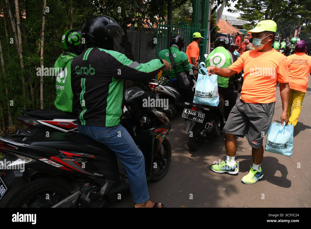 5 septembre 2019, Cipayung, Jakarta, Indonésie : des volontaires donnent des colis alimentaires aux chauffeurs de moto-taxi en ligne dans la région de Cipayung, Jakarta, le 18 avril 2020. Pas moins de 200 colis alimentaires ont été distribués en ligne aux chauffeurs de motos-taxis, car depuis que la co-pandémie a eu lieu en Indonésie, leurs revenus ont diminué. Depuis les nombreuses commandes précédentes pour le transport, les utilisateurs utilisent maintenant des chauffeurs pour commander de la nourriture, magasiner pour les nécessités quotidiennes ou livrer des marchandises. (Crédit image : © Dasril Roszandi/ZUMA Wire) Banque D'Images