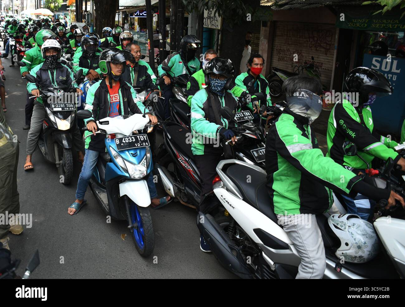 5 septembre 2019, Cipayung, Jakarta, Indonésie : les chauffeurs de moto-taxi en ligne sont prêts à faire la queue pour obtenir des provisions de bénévoles dans la région de Cipayung, Jakarta, le 18 avril 2020. Pas moins de 200 colis alimentaires ont été distribués en ligne aux chauffeurs de motos-taxis, car depuis que la co-pandémie a eu lieu en Indonésie, leurs revenus ont diminué. Depuis les nombreuses commandes précédentes pour le transport, les utilisateurs utilisent maintenant des chauffeurs pour commander de la nourriture, magasiner pour les nécessités quotidiennes ou livrer des marchandises. (Crédit image : © Dasril Roszandi/ZUMA Wire) Banque D'Images