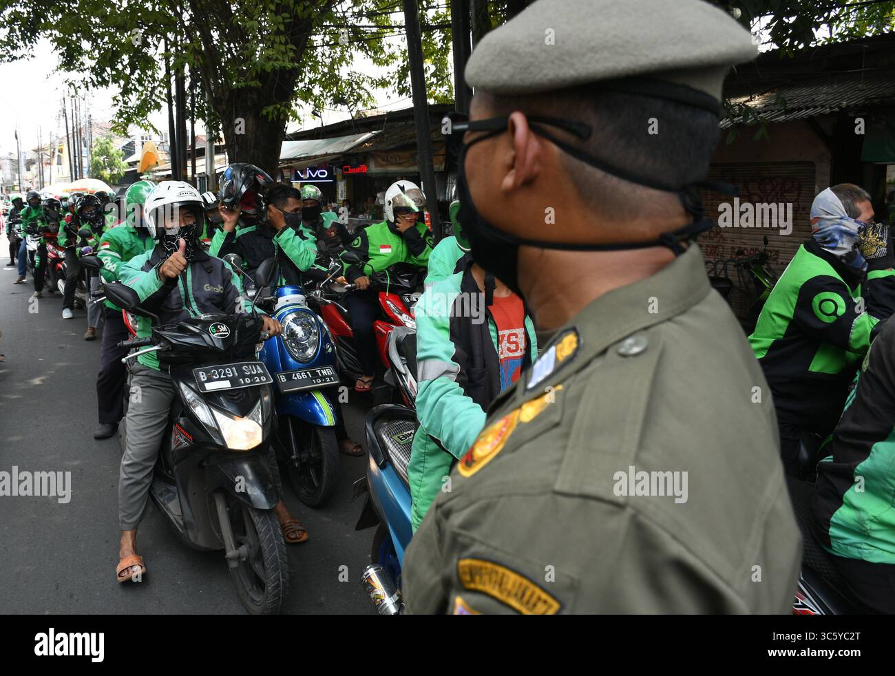 5 septembre 2019, Cipayung, Jakarta, Indonésie : les chauffeurs de moto-taxi en ligne sont prêts à faire la queue pour obtenir des provisions de bénévoles dans la région de Cipayung, Jakarta, le 18 avril 2020. Pas moins de 200 colis alimentaires ont été distribués en ligne aux chauffeurs de motos-taxis, car depuis que la co-pandémie a eu lieu en Indonésie, leurs revenus ont diminué. Depuis les nombreuses commandes précédentes pour le transport, les utilisateurs utilisent maintenant des chauffeurs pour commander de la nourriture, magasiner pour les nécessités quotidiennes ou livrer des marchandises. (Crédit image : © Dasril Roszandi/ZUMA Wire) Banque D'Images