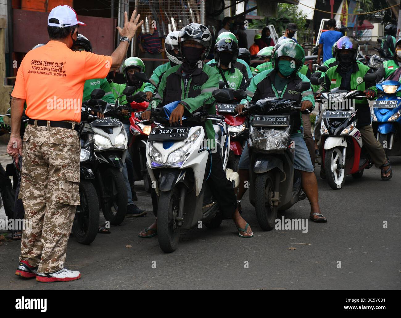 5 septembre 2019, Cipayung, Jakarta, Indonésie : des volontaires donnent des colis alimentaires aux chauffeurs de moto-taxi en ligne dans la région de Cipayung, Jakarta, le 18 avril 2020. Pas moins de 200 colis alimentaires ont été distribués en ligne aux chauffeurs de motos-taxis, car depuis que la co-pandémie a eu lieu en Indonésie, leurs revenus ont diminué. Depuis les nombreuses commandes précédentes pour le transport, les utilisateurs utilisent maintenant des chauffeurs pour commander de la nourriture, magasiner pour les nécessités quotidiennes ou livrer des marchandises. (Crédit image : © Dasril Roszandi/ZUMA Wire) Banque D'Images