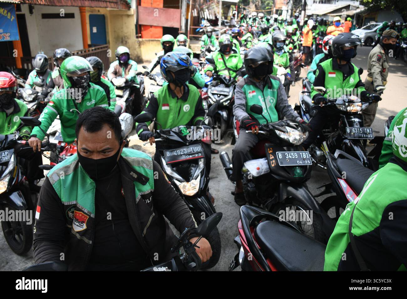 5 septembre 2019, Cipayung, Jakarta, Indonésie : les chauffeurs de moto-taxi en ligne sont prêts à faire la queue pour obtenir des provisions de bénévoles dans la région de Cipayung, Jakarta, le 18 avril 2020. Pas moins de 200 colis alimentaires ont été distribués en ligne aux chauffeurs de motos-taxis, car depuis que la co-pandémie a eu lieu en Indonésie, leurs revenus ont diminué. Depuis les nombreuses commandes précédentes pour le transport, les utilisateurs utilisent maintenant des chauffeurs pour commander de la nourriture, magasiner pour les nécessités quotidiennes ou livrer des marchandises. (Crédit image : © Dasril Roszandi/ZUMA Wire) Banque D'Images