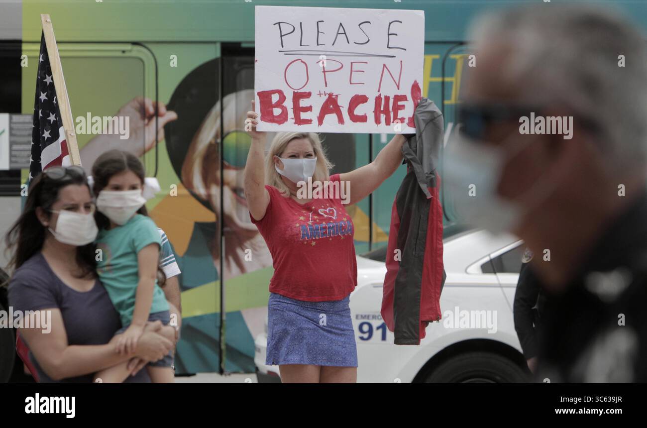 14 mai 2020, Miami, FL, États-Unis : Miami, Floride, le 14 mai 2020- Une manifestante qui a refusé de donner son nom tient une pancarte alors que le gouverneur Ron DeSantis parle à la presse lors d'une conférence de presse concernant une première phase d'ouverture pour les comtés de Broward et Miami-Dade... L'événement au centre commercial fermé Downtown Doral incluait Gimenez et le maire du comté de Broward, Dale Holness. Les comtés adjacents sont les deux derniers en Floride avec des commandes d'urgence en suspens fermant les salles à manger, et les deux ont annoncé des plans pour lever ces restrictions lundi. (Crédit image : © TNS via ZUMA Wire) Banque D'Images