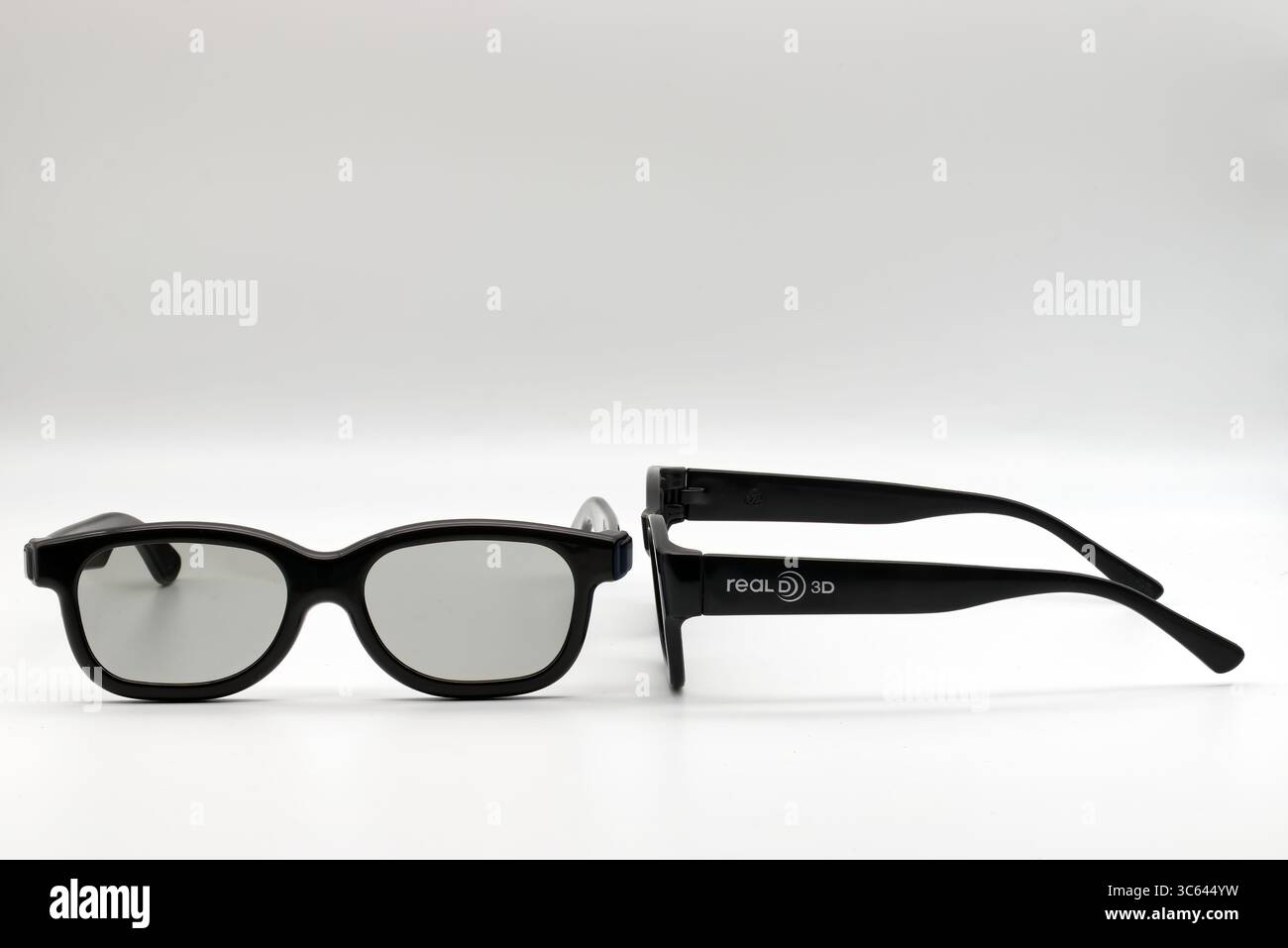 Une paire de lunettes RealD 3D noires conçues pour regarder des expériences cinématographiques immersives sur fond blanc. Banque D'Images