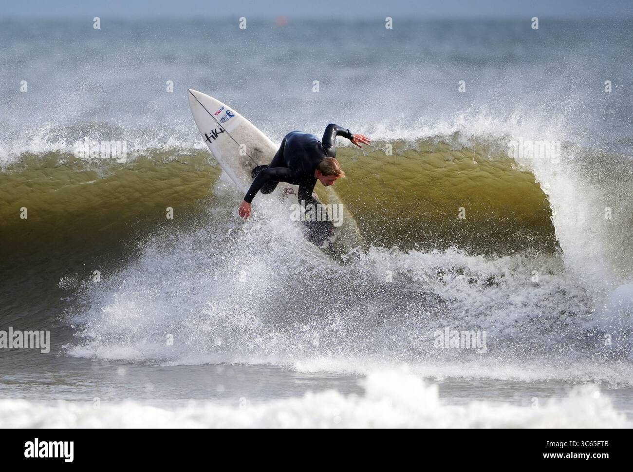 Surfeurs à la plage de Tynemouth Longsands sur la côte nord-est. Date de la photo : jeudi 31 juillet 2025. Banque D'Images