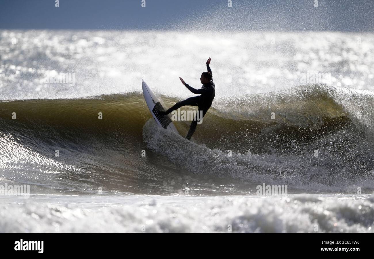 Surfeurs à la plage de Tynemouth Longsands sur la côte nord-est. Date de la photo : jeudi 31 juillet 2025. Banque D'Images