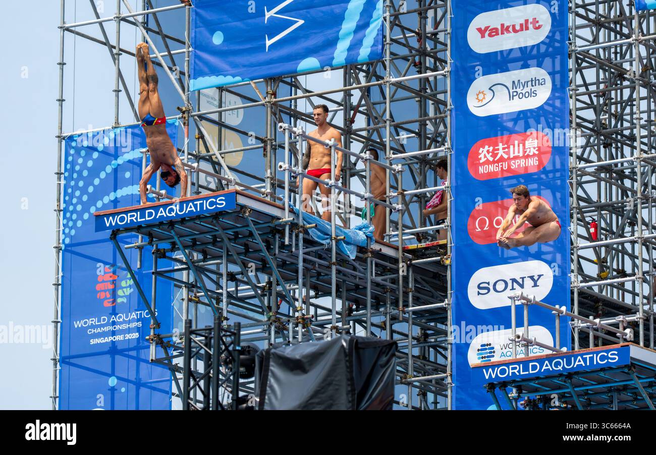 Singapour, Singapour - 25 juillet 2025 : vue de plongeurs sur la plate-forme World Aquatics à Siloso Beach Walk, une symphonie de focus contre les bannières bleues et les échafaudages. Banque D'Images