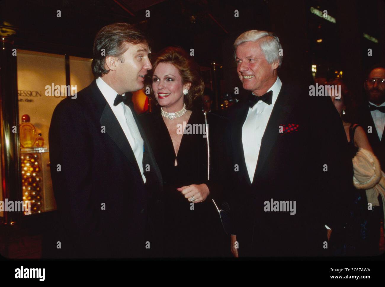 12 décembre 1987 - New York, N.y, États-Unis - DONALD TRUMP, à gauche, personnalité de la télévision PHYLLIS GEORGE, au centre, et son mari ancien gouverneur du Kentucky JOHN Y. BROWN Jr. Parlez lors d'une fête pour célébrer la sortie de 'Trump : l'art de l'accord' au Trump Tower Atrium à New York. (Crédit image : © Sonia Moskowitz Gordon/ZUMA Wire) Banque D'Images
