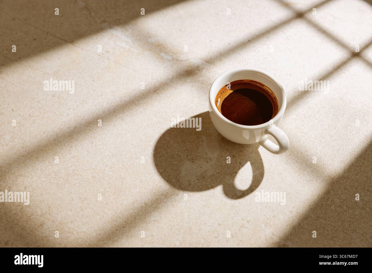 Une tasse de café noir chaud sur une table au soleil Banque D'Images