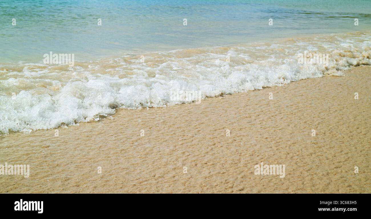 Vagues de l'océan bleu s'affrontant sur la plage de sable Banque D'Images