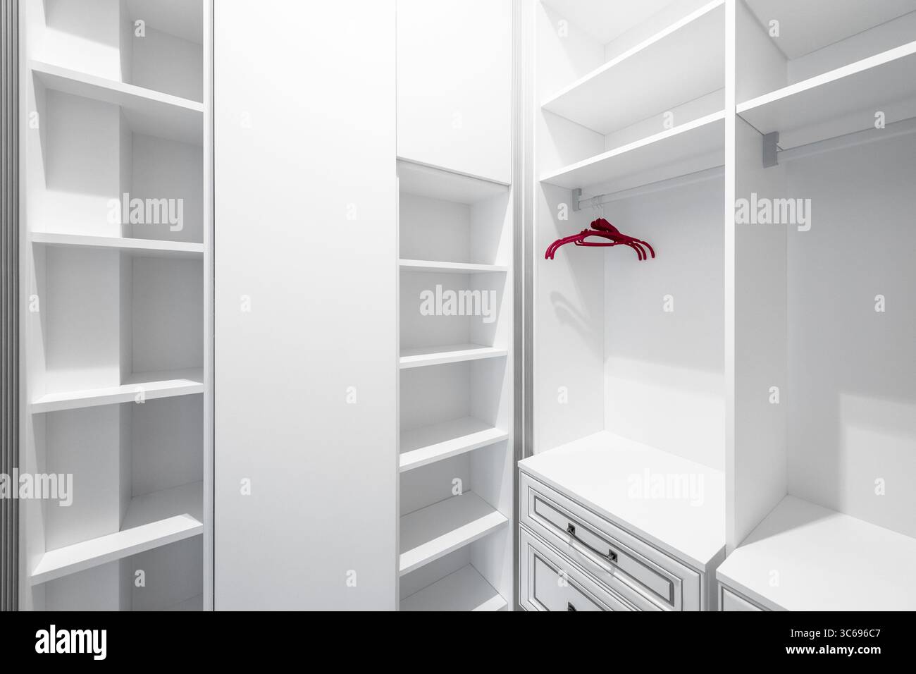 Armoire vide avec trois cintres. Placard d'angle vide avec trois cintres rouges. Banque D'Images