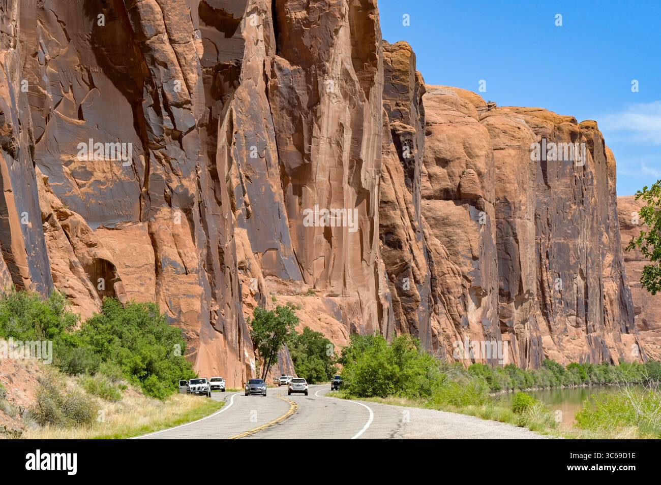 Moab, Utah, États-Unis - 25 mai 2025 : véhicules circulant sur Potash Road le long du fleuve Colorado sous d'énormes rochers près de Moab Banque D'Images