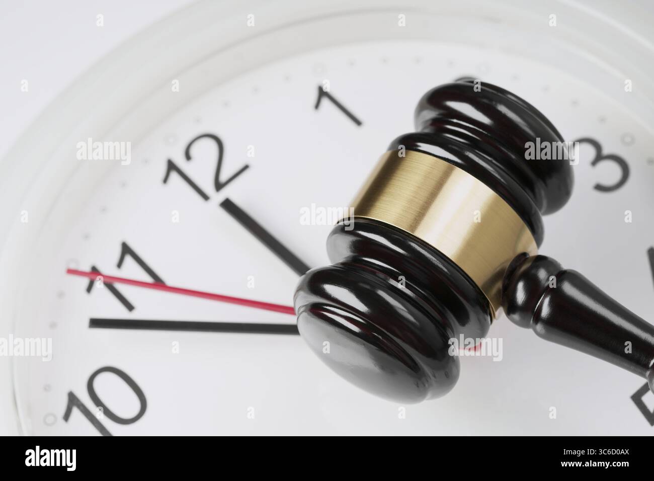 Loi, législation, justice et concept de temps avec une vue de dessus d'un marteau de juge sur une horloge. Banque D'Images