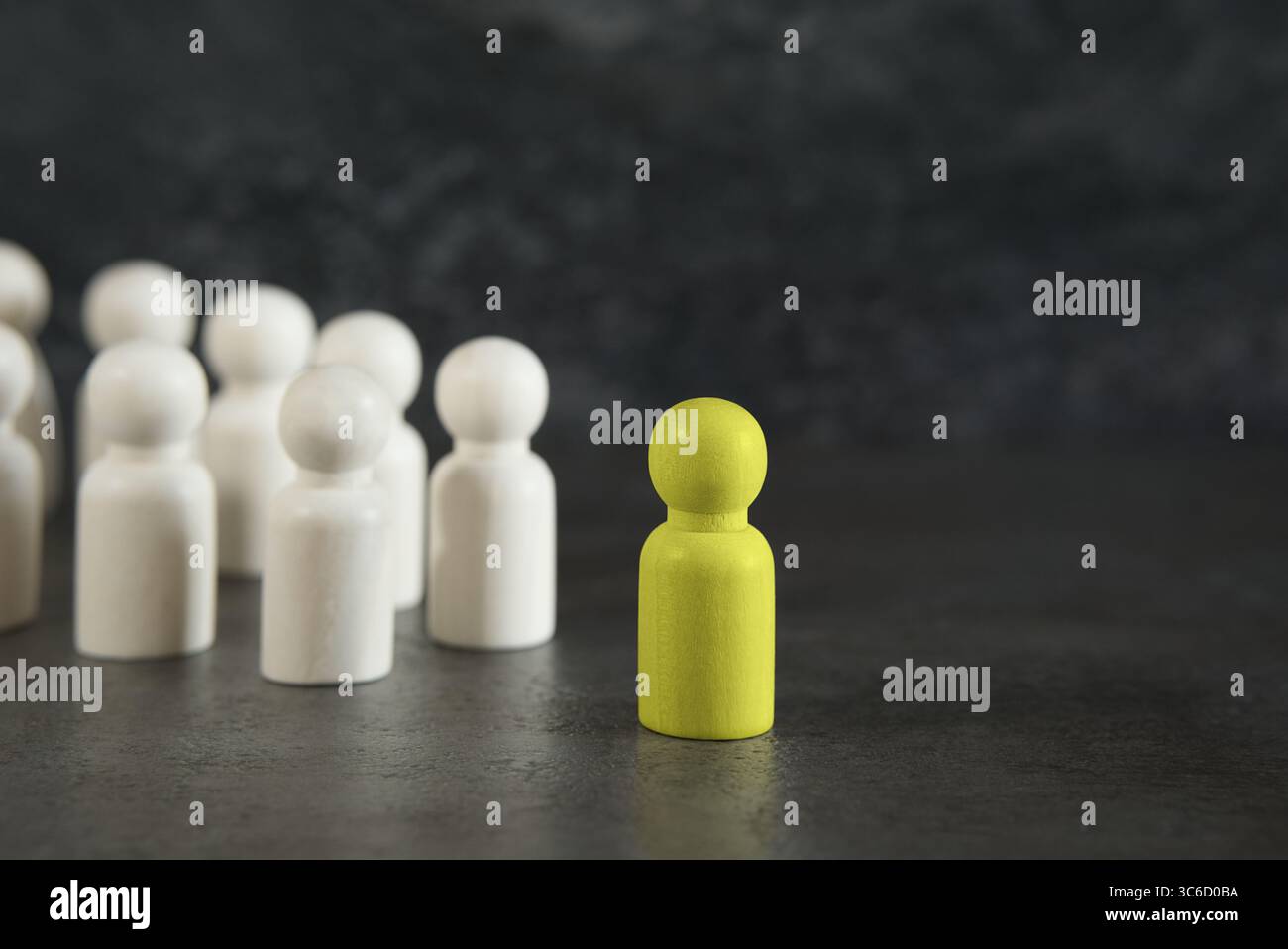 Démarquez-vous, de nouvelles idées et un leadership dans le concept d'affaires avec un chef de pion en bois jaune se démarquant et menant parmi les autres sur fond gris. Banque D'Images