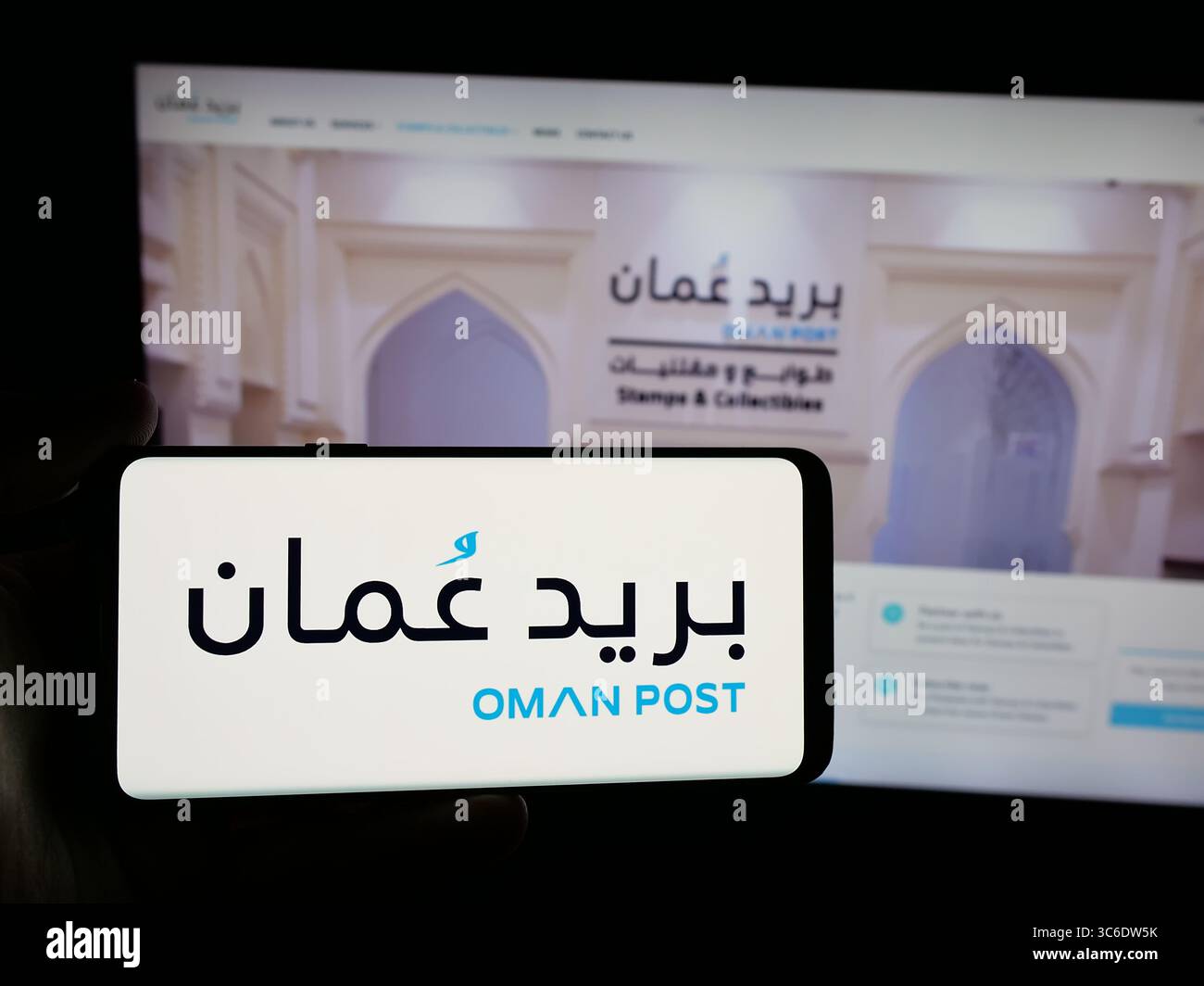 Stuttgart, Allemagne - 06-20-2025 : personne tenant un smartphone avec le logo de la société de services postaux omanais Oman Post sur l'écran devant le site Web. Banque D'Images