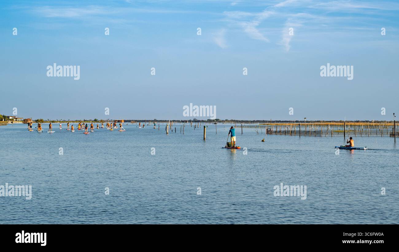 Stand Up Paddle (SUP) : un groupe organisé de personnes partant pour une excursion dans la lagune de Porto Caleri ; partie du parc régional du delta du Pô, Rosolina Banque D'Images